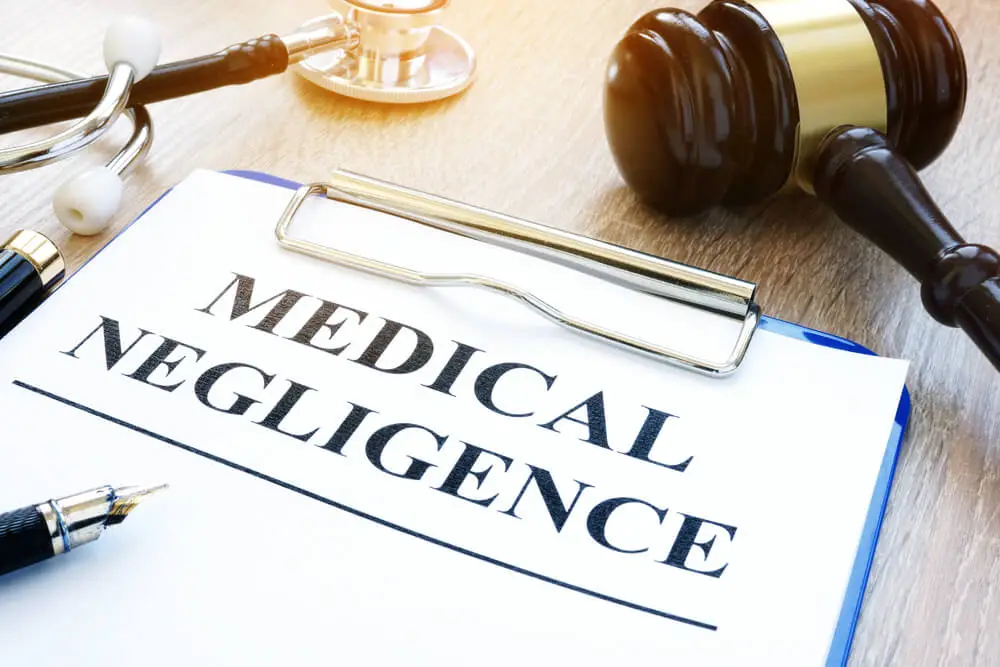 Medical Negligence Document on Blue Clipboard with Solicitors Gavel